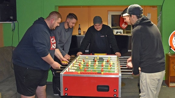 Junge Männer spielen am Kicker