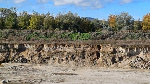 Blick auf den Rand der Kiesgrube, wo Erdbrocken abgerutscht sind.