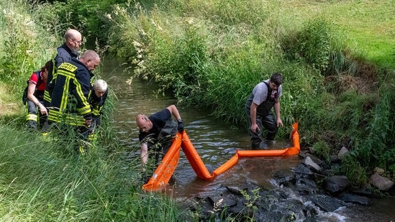 Kameraden der Feuerwehr Oderwitz haben im Landwasser eine Ölsperre eingesetzt.