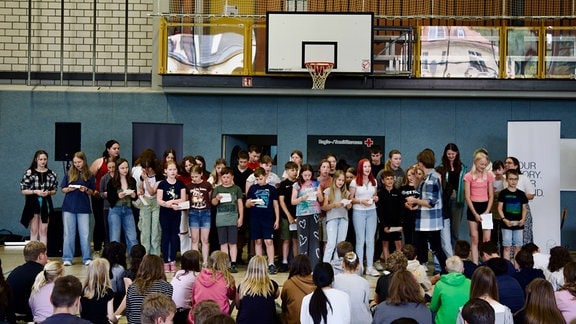 Ein Gruppe Schülerinnen und Schüler singt.