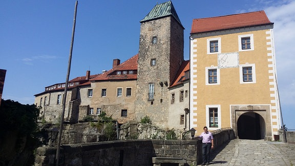 Ein Mann steht vor dem Eingang zur Burg Hohnstein