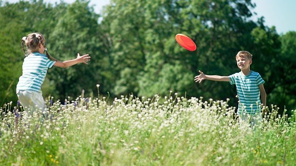 Ein Junge und ein Mädchen spielen Frisbee
