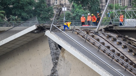 Fachleute begutachten eine Bruchstelle an der eingestürzten Carolabrücke. 