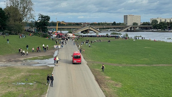 Menschen auf dem Elberadweg blockieren die Abrissfahrzeuge