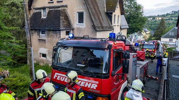 Feuerwehrfahrzeuge und Einsatzkräfte befinden sich vor einem Haus in Schwarzenberg.
