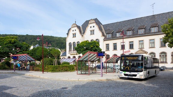 Busbahnhof auf dem Postplatz, im HIntergrund das ehemalige Postgebäude in Aue