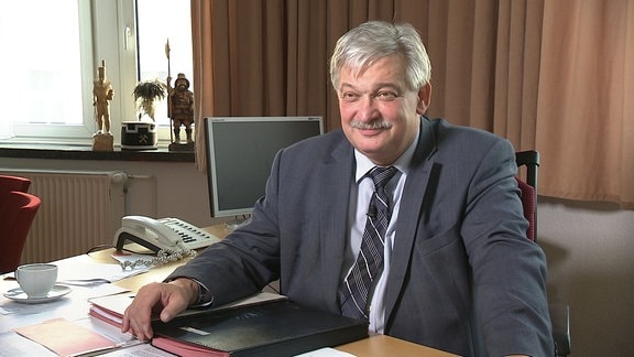 Der Bürgermeister von Aue, Heinrich Kohl, sitzt an einem Schreibtisch.