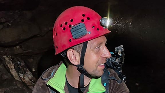 Mann mit Helm und Stirnlampe