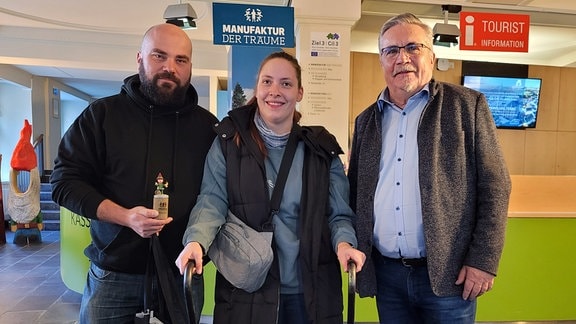 Drei Menschen stehen im Foyer der "Manufaktur der Träume" in Annaberg-Buchholz.