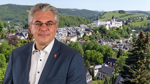 Portrait: Ruben Gehart, Oberbürgermeister von Schwarzenberg, im Hintergrund ein Schloss und eine Stadt.