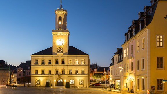 Ansicht eines beleuchteten Marktplatzes mit Rathaus