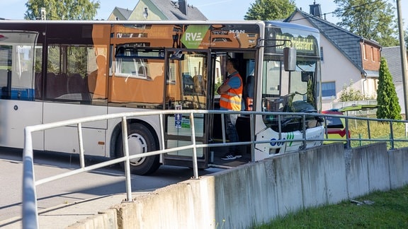 Ein an einem Geländer verunglückter Schulbus. 