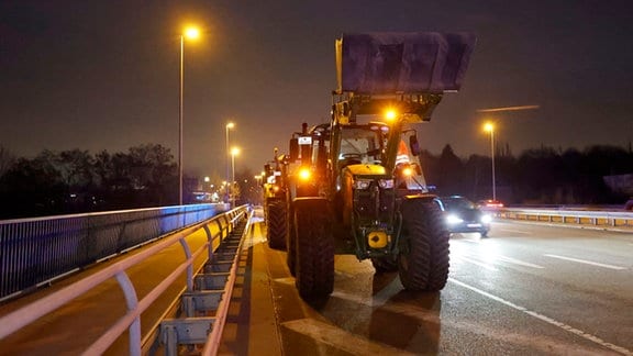 Traktoren mit Schaufel stehen auf rechtem Fahrstreifen einer Brücke, die über die A4 führt