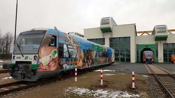 Vor dem Betriebsbahnhof der Vogtlandbahn steht ein bunter Zug