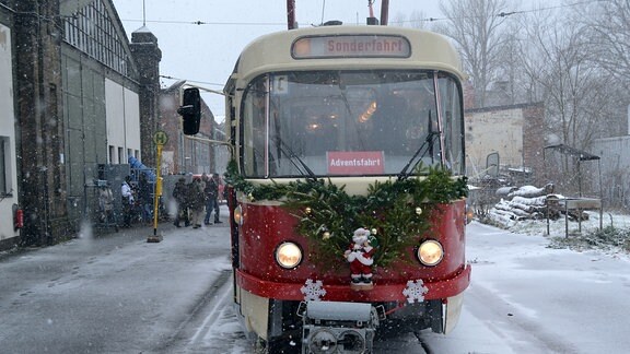 Ein Tatra-Straßenbahnzug von vorn mit der Aufschrift "Adventsfahrt" im Schneetreiben