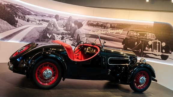 Ein schwarzes DKW-Cabrio mit roter Innenpolsterung steht in einem Museum