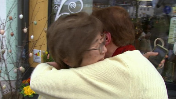 Zwei Frauen umarmen sich innig.