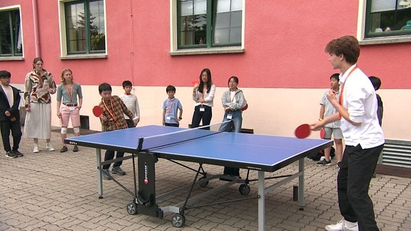 Jugendliche spielen Tischtennis.