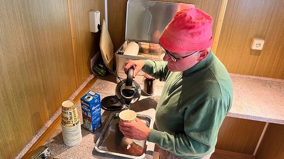 Ein Mann bereitet Kaffee zu.