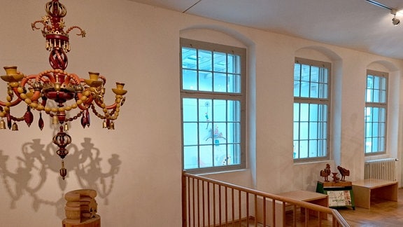 In einem Treppenhaus hängt ein erzgebirgischer Leuchter.