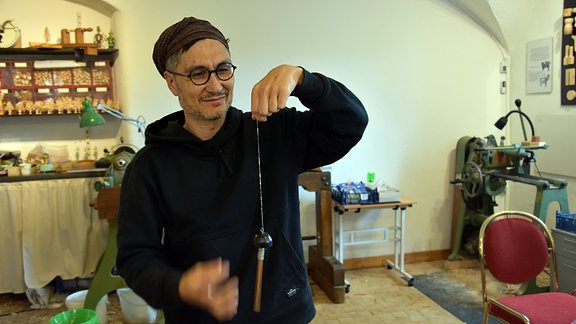 Ein Mann (Karl Logge) mit einer drehenden Handspindel.