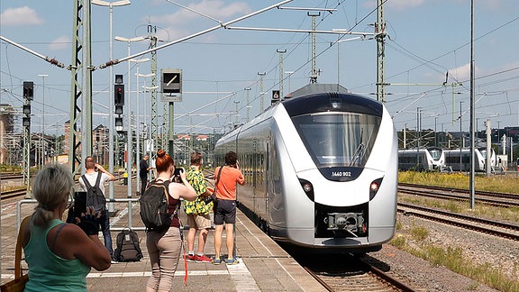 Akku-Zug in Chemnitz fährt ein auf dem Chemnitzer Hbf. Schaulustige fotografieren die Einfahrt.