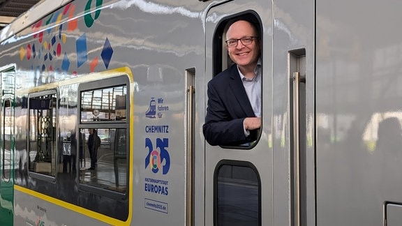 Der Chemnitzer Oberbürgermeister Sven Schulze schaut wie ein Lokführer aus einem Triebwagenfenster.