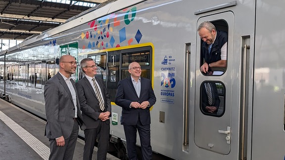 Jan Kleinwechter (MRB), Mathias Korda (VMS) und der Chemnitzer OB Sven Schulze vor einem Triebwagen.