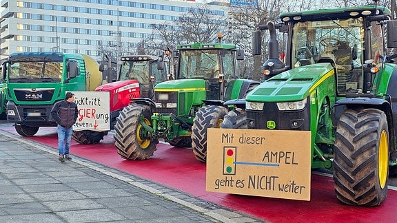 Landwirtschaftliche Fahrzeuge parken aus Protest auf einem Radweg.