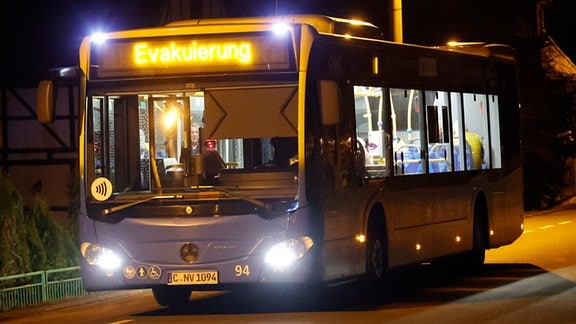Ein Nahverkehrsbus steht auf einer dunklen Straße mit der Aufschrift "Evakuierung".
