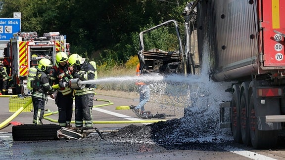 Die Feuerwehr löscht einen brennenden Lkw