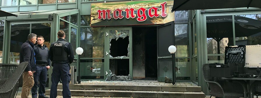 Hinter einem Absperrband der Polizei ist die zerstörte Tür eines Restaurants zu sehen | Bildrechte: MDR/Mario Unger Hinter einem Absperrband der Polizei ist die zerstörte Tür eines Restaurants zu sehen