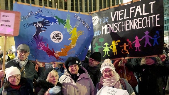 Anhänger der Initiative "Omas gegen Rechts" stehen mit Transparenten auf dem Neumarkt in Chemnitz.