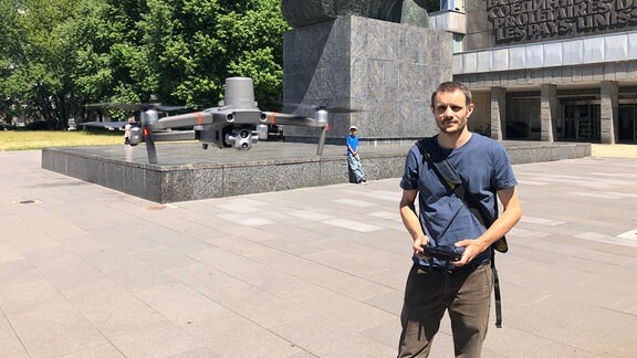 Ein Mann steuert eine Drohne vor dem Karl-Marx-Monument in Chemnitz