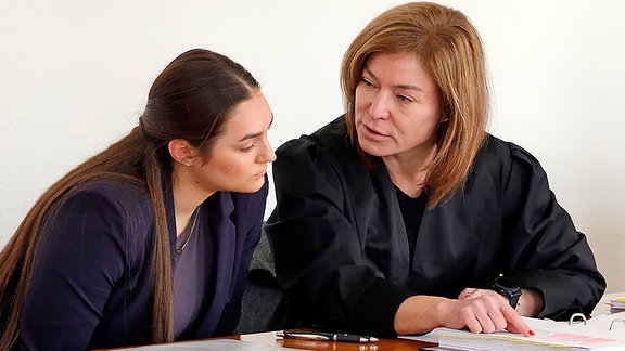Zwei Frauen sitzen nebeneinander an einem Tisch beim Aktenstudium