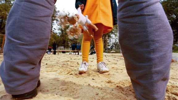 Symbolfoto - Kind wird von einem Mann auf einem Spielplatz angesprochen.