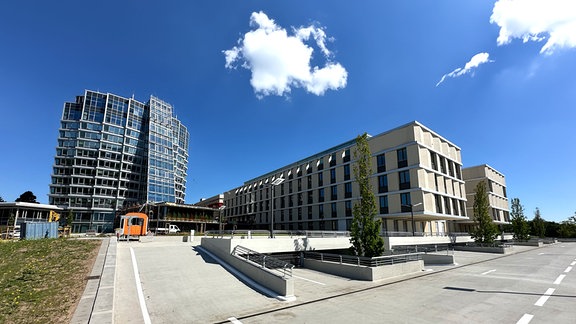 Blick von einer Betonfläche auf ein Hochhaus und einen flacheren Neubau am Klinikum Chemnitz.