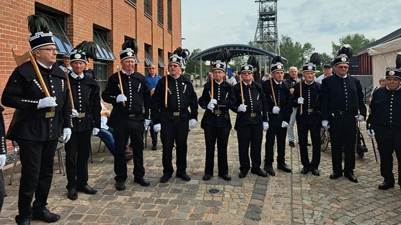 Bergmänner: Zehn Herren in Bergmannshabit, der traditionellen Kleidung der Bergleute, stehen in einer Reihe.