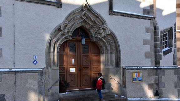Krimiautorin Anett Steiner vor dem Portal der St. Marienkirche in Marienberg. 