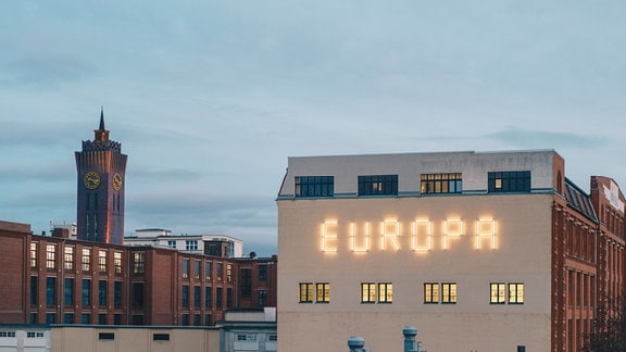 Auf einer Häuserwand steht auf einer Hausfassade in leuchtenden Buchstaben "EUROPA".