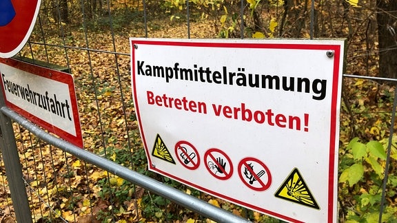 Ein abgeschossener Bauzaun vor einem Waldweg mit dem Schild "Kampfmittelräumung - Betreten verboten!" 
