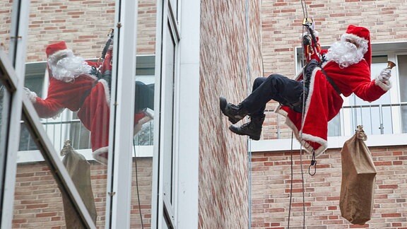 Ein als Nikolaus verkleideter Feuerwehr-Höhenretter seilt sich vom Dach des Kinder-Universitätsklinikums Eppendorf (UKE) ab. 
