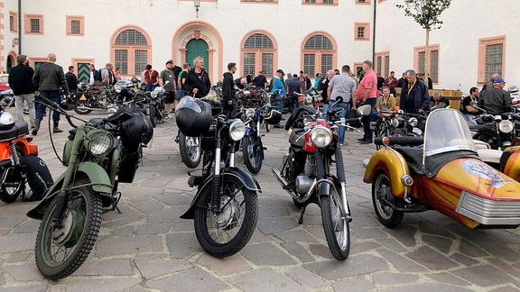 Historische Motorräder stehen beim Oldtimer-Herbsttreffen auf Schloss Augustusburg im Innenhof.