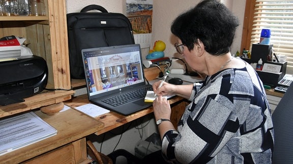 Claudia Kuhn, Betreiberin der Pension "Nostalgie" in Chemnitz, schreibt an einem Arbeitsplatz eine Quittung.