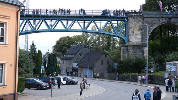Menschen laufen auf einem ehemaligen Eisenbahn-Viadukt. 