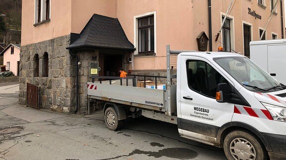 Ein Lkw mit Ladefläche steht vor dem Rathaus Gornsdorf