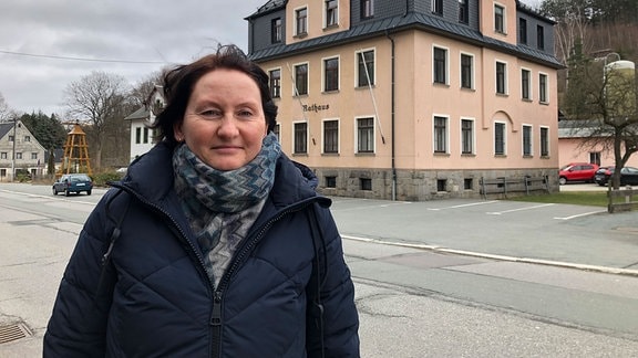 Porträt der Bürgermeisterin von Gornsdorf. Im Hintergrund das Rathaus