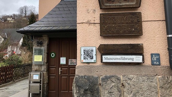 Ein Schild mit der Aufschrift "Strumpfmuseum" am alten Rathaus von Gornsdorf