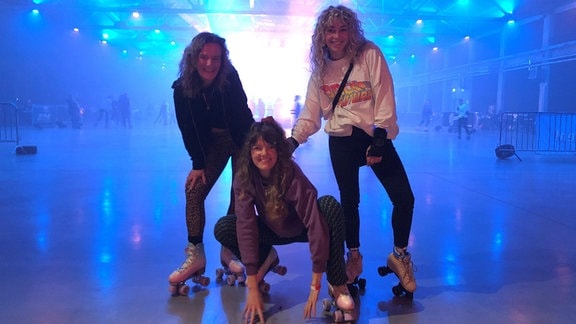 Drei junge Frauen posieren bei der Roller-Skate-Disko in Chemnitz.