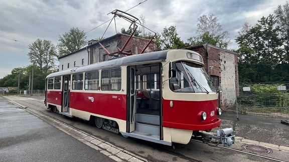 Eine Straßenbahn aus tschechoslowakischer Herstellung mit rotem Farbband und geöffneter Tür